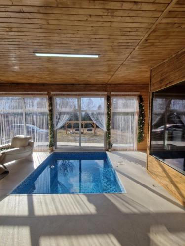 a large room with a swimming pool in a house at Casutele Anei- Aframe&Spa in Rişca