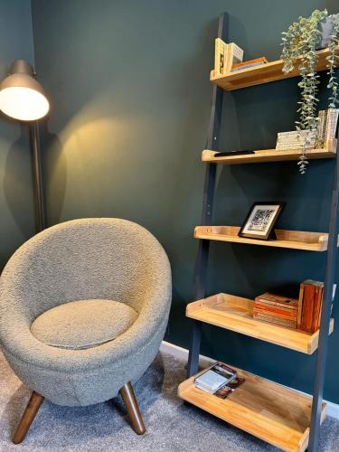 a chair sitting next to a book shelf at Quarry Heights in Bowness-on-Windermere