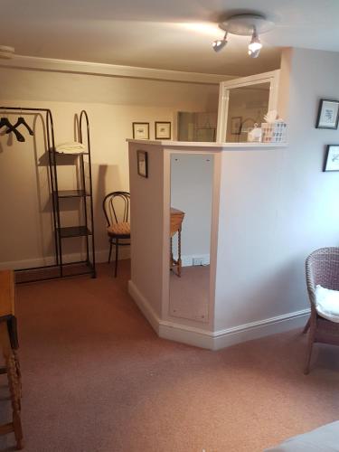 a living room with a table and a mirror at Lammas Park House in Dawlish