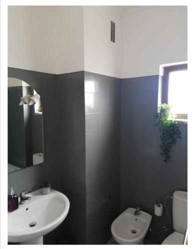 a bathroom with a sink and a toilet and a mirror at Vieira's House in Barreiro