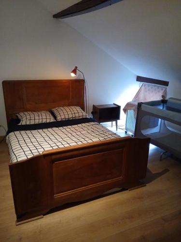 a large wooden bed in a room with a lamp at Chic et relax familial in Montmarault