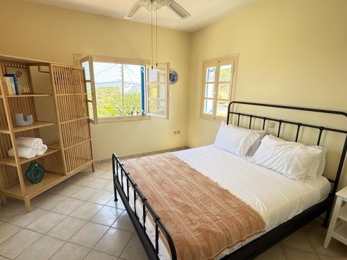 a bedroom with a large bed and a window at Villa Galazia in Megalochori