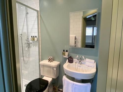 a bathroom with a sink and a toilet and a shower at The Bear Tattenhall in Tattenhall