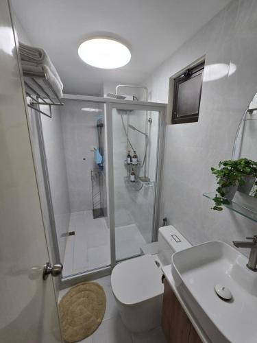 a bathroom with a shower and a toilet and a sink at Kai's Luxe Balcony Suite at Royal Oceancrest Mactan in Mactan Island