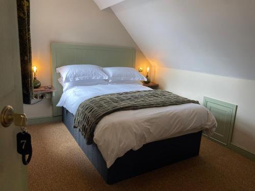 a bedroom with a bed with white sheets and pillows at The Bear Tattenhall in Tattenhall