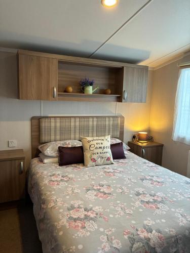 a bedroom with a bed with a floral bedspread at Bordeaux sea view no 9 in Ardentinny