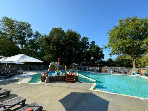 a swimming pool with chaise lounge chairs and a swimming pool at Tente avec terrasse - 2 pers. - API-1-52-2040 in Grayan-et-lʼHôpital