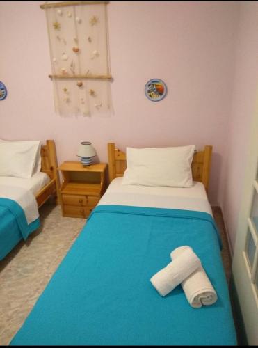 a bedroom with two beds with towels on the bed at AGNANTI in Palekastron