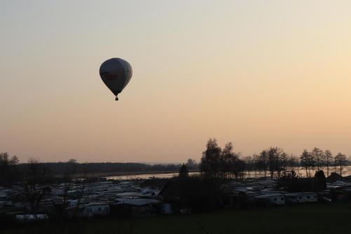a hot air balloon flying in the sky over a town at Dümmerblick II in Hüde
