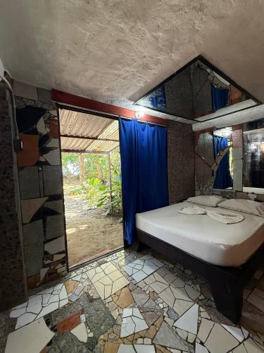 a bedroom with a bed in a room with a window at Rocking J's in Puerto Viejo