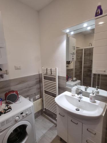 a bathroom with a washing machine and a sink at sunflower apartment in Domaso