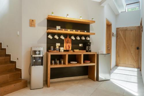 a kitchen with a refrigerator and a shelf with cups at Casa Blú Huatulco in Santa Cruz Huatulco