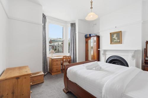a bedroom with a large bed and a fireplace at Charming Sandy Bay Cottage in Sandy Bay