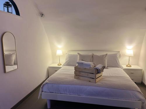 a bedroom with a white bed with two lamps at Tracce nel Borgo in Putignano