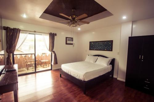 a bedroom with a bed and a ceiling fan at Oasis Resort and Spa in Boracay