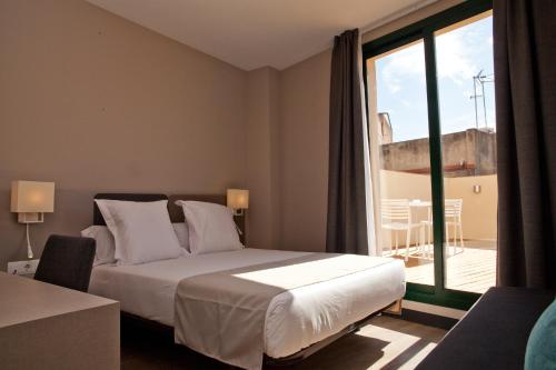 Ένα ή περισσότερα κρεβάτια σε δωμάτιο στο May Ramblas Hotel