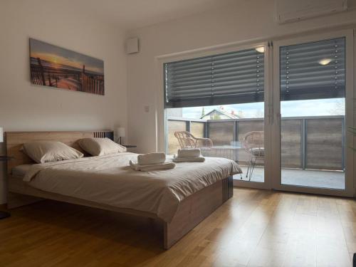 a bedroom with a large bed and a balcony at Pipanova Cosy Nest with Balcony & Free Parking in Ljubljana