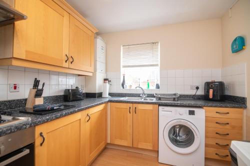 a kitchen with a washing machine and a sink at Fantastic 4 bed house with 3 bathrooms in pleasant location in Great Barr