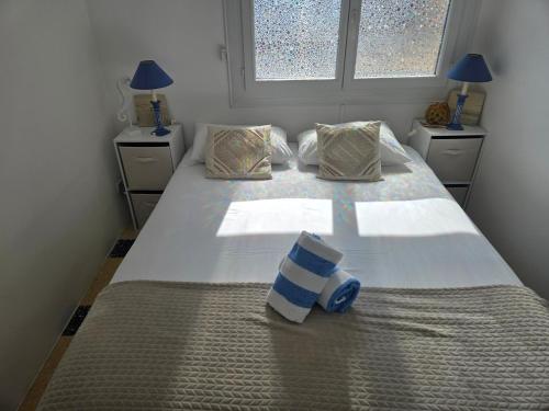 a bedroom with a large white bed with two windows at Le 18 plage in Valras-Plage