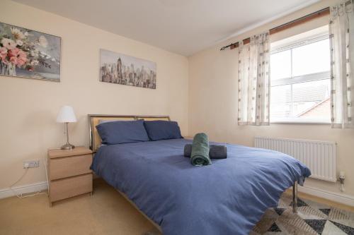 a bedroom with a large bed with a blue blanket at Fantastic 4 bed house with 3 bathrooms in pleasant location in Great Barr