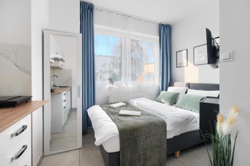a bedroom with a large bed and a mirror at Mini Apartamenty Poznań in Poznań