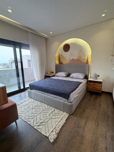 a bedroom with a large bed and a large window at Charming privado in Madinaty