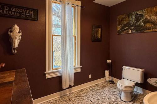 a bathroom with a toilet and a window at Addie House in Lead