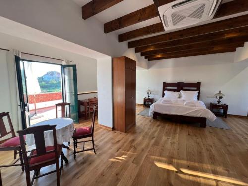a bedroom with a bed and a table and chairs at Colonial Farmhouse with Cottage - Lugar Minas da Caveira in Grândola