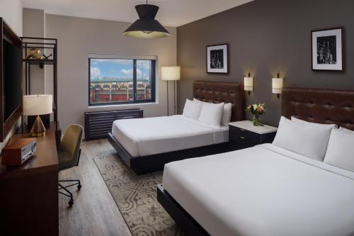 a hotel room with two beds and a desk at Watt Hotel Tapestry Collection by Hilton in Rahway