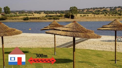 a group of straw umbrellas on a beach at Casa da Oriola in Oriola