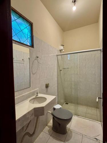 a bathroom with a toilet and a sink and a shower at Bravo Inn Hotel Coxim in Coxim