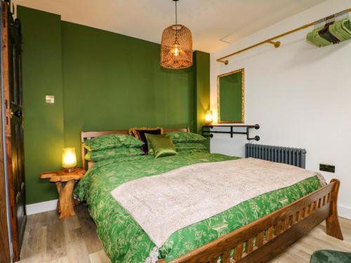 a green bedroom with a large bed with green walls at Shell Cottage in Bournemouth