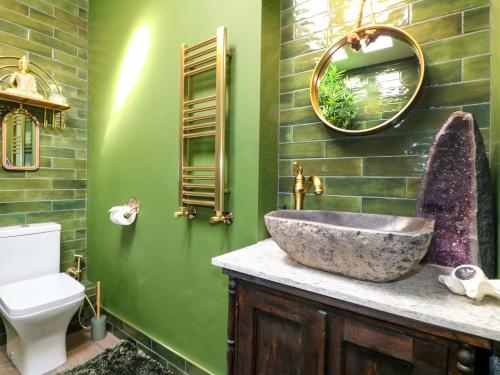 a bathroom with a stone sink and green walls at Shell Cottage in Bournemouth