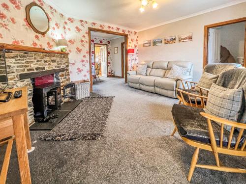 a living room with a fireplace and a couch at Laxdale Cottage in Leverburgh