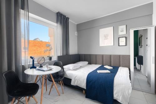 a bedroom with a bed and a table and chairs at Mini Apartamenty Poznań in Poznań