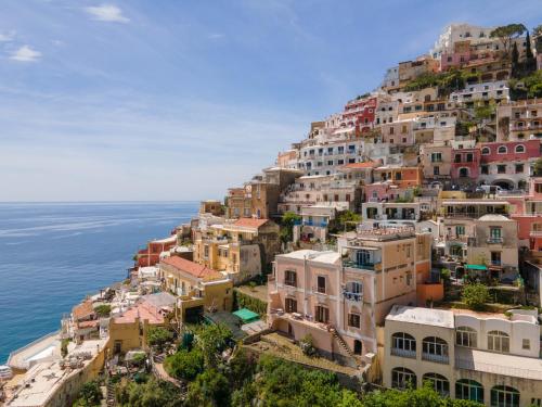 a group of houses on a hill next to the ocean at Casa Sam Positano in Positano