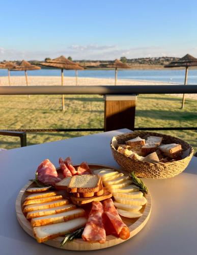 a plate of cheese and crackers and a basket of bread at Casa da Oriola in Oriola