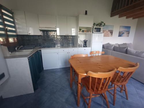 a kitchen with a wooden table and some chairs at Gîte du Trempal in Audruicq