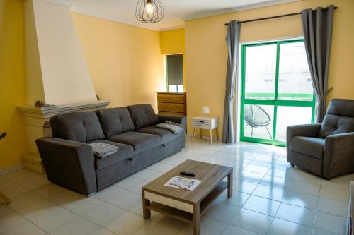 a living room with a couch and a chair and a table at Vagueira beach in Praia da Vagueira