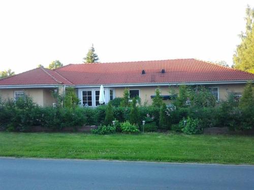 a house with a red roof on a green yard at Workers Stay - Temporary House Umeå in Umeå