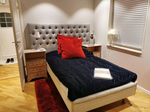 a bedroom with a large bed with a red pillow at Workers Stay - Temporary House Umeå in Umeå