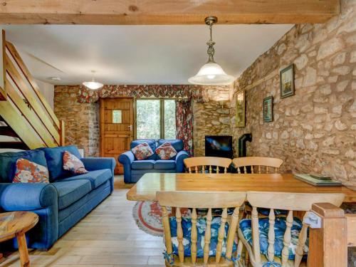 a living room with a blue couch and a table at Allerford- Ukc4920 in Timberscombe