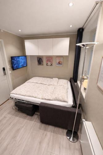a bedroom with a bed and a lamp in it at Liten studioleilighet meget sentralt i sentrum, 3 minutter fra torget in Trondheim