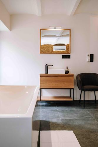 a bathroom with a sink and a tub and a mirror at Gîte Grise Pierre in Herve