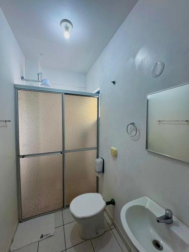 a bathroom with a shower and a toilet and a sink at Oceano Hotel de Barra Velha in Barra Velha