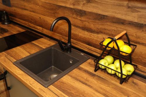 a kitchen counter with a sink and a basket of apples at Podostroška želja in Danilovgrad
