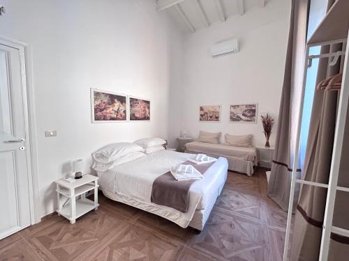 a white bedroom with a bed and a couch at Vicolo Doria Apartment in Rome