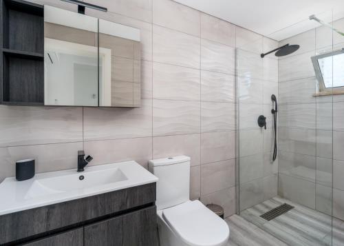 a bathroom with a toilet and a sink and a shower at Villa Garden - 22 Guests - 2 Pools in Albufeira