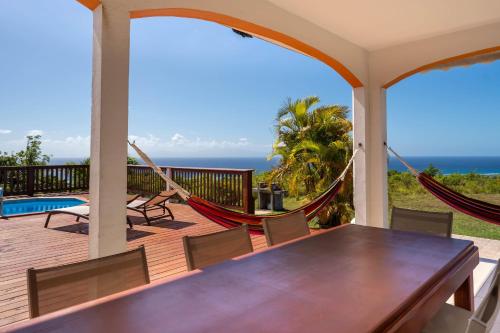 a porch with a hammock and a view of the ocean at Villa O'Bed in Grand-Bourg