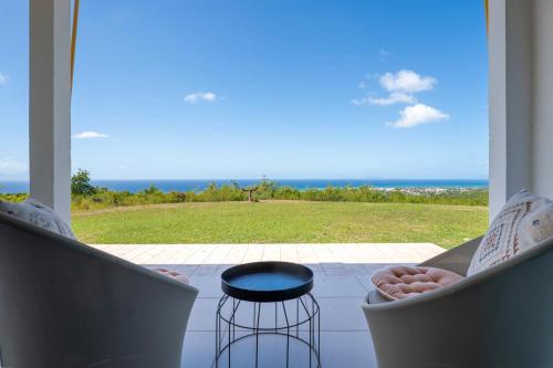 a room with two chairs and a view of the ocean at Villa O'Bed in Grand-Bourg